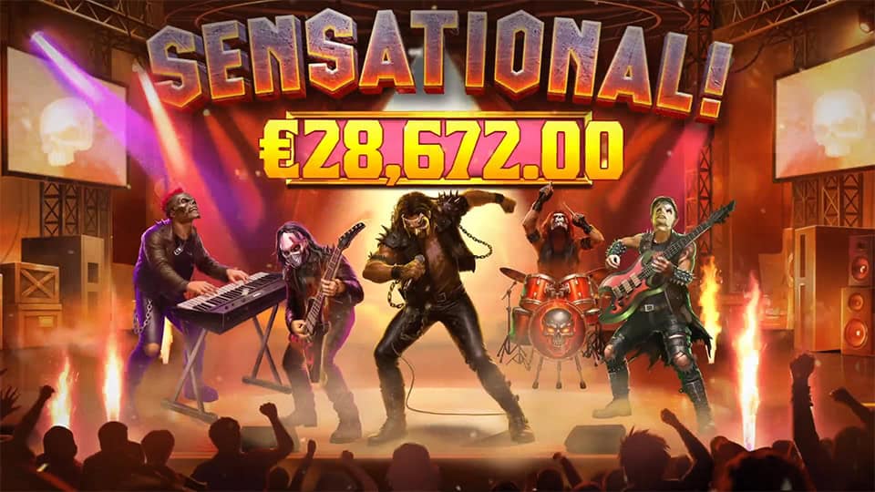 Full rock band on stage with “SENSATIONAL!” win banner and crowd cheering.